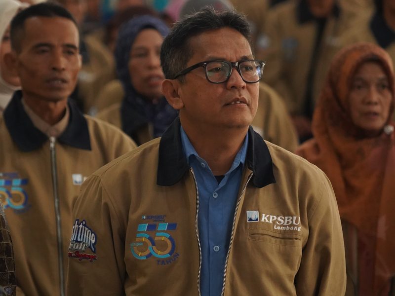 Anggota koperasi memakai work jacket cokelat muda dengan bordir logo KPSBU Lembang dan patch 55 tahun